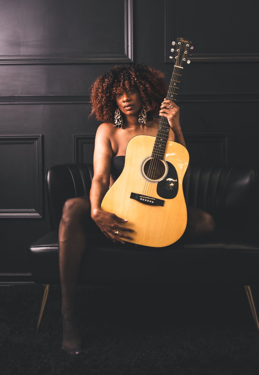 empowering-solo- portrait-boudoir-photography-on-black-sofa-with-guitar.jpg