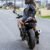 woman on her black ninja 500 motorbike in a black leather jacket looking back through her black helmet