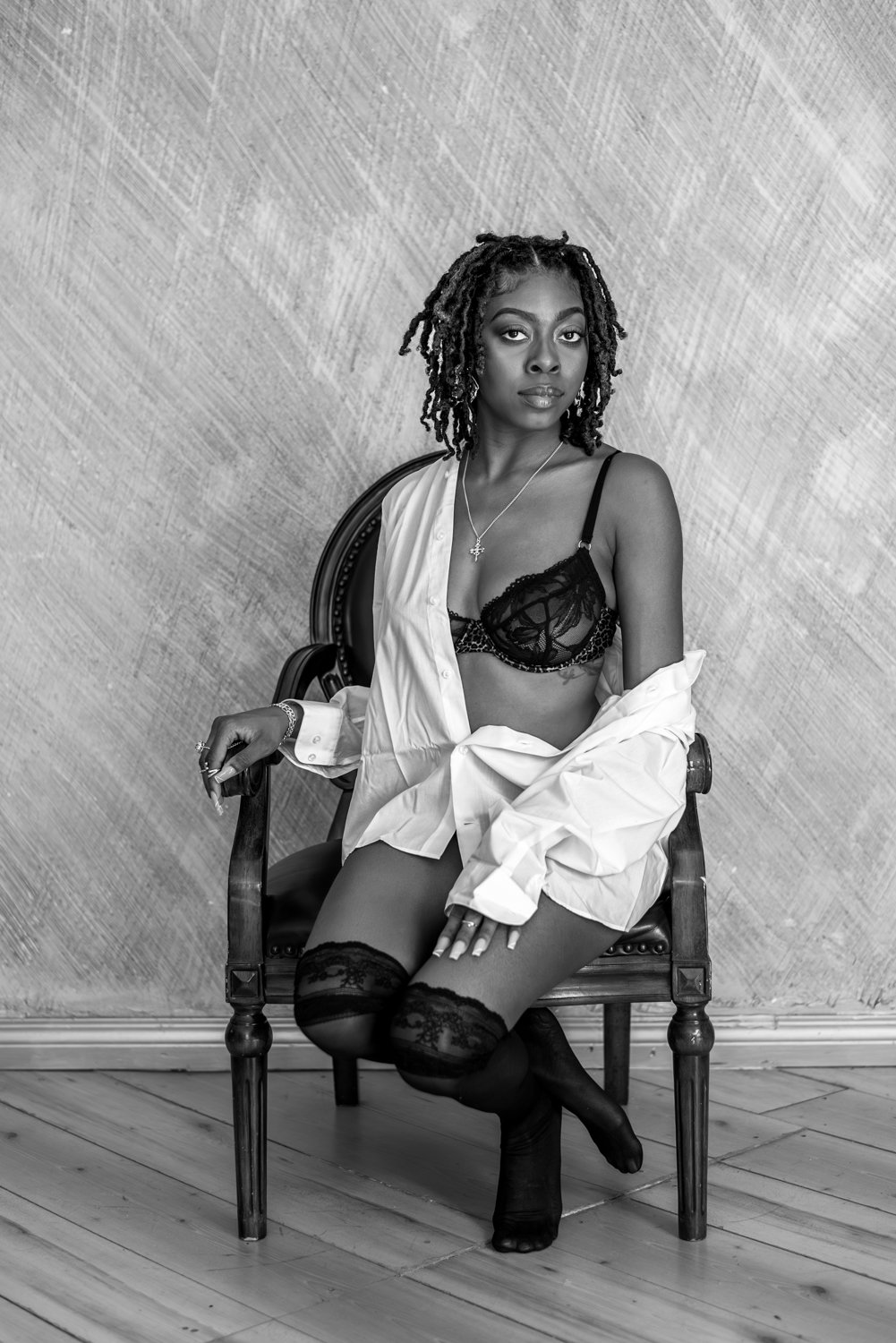 boudior portait of a woman in a man's shirt sitting on a chair